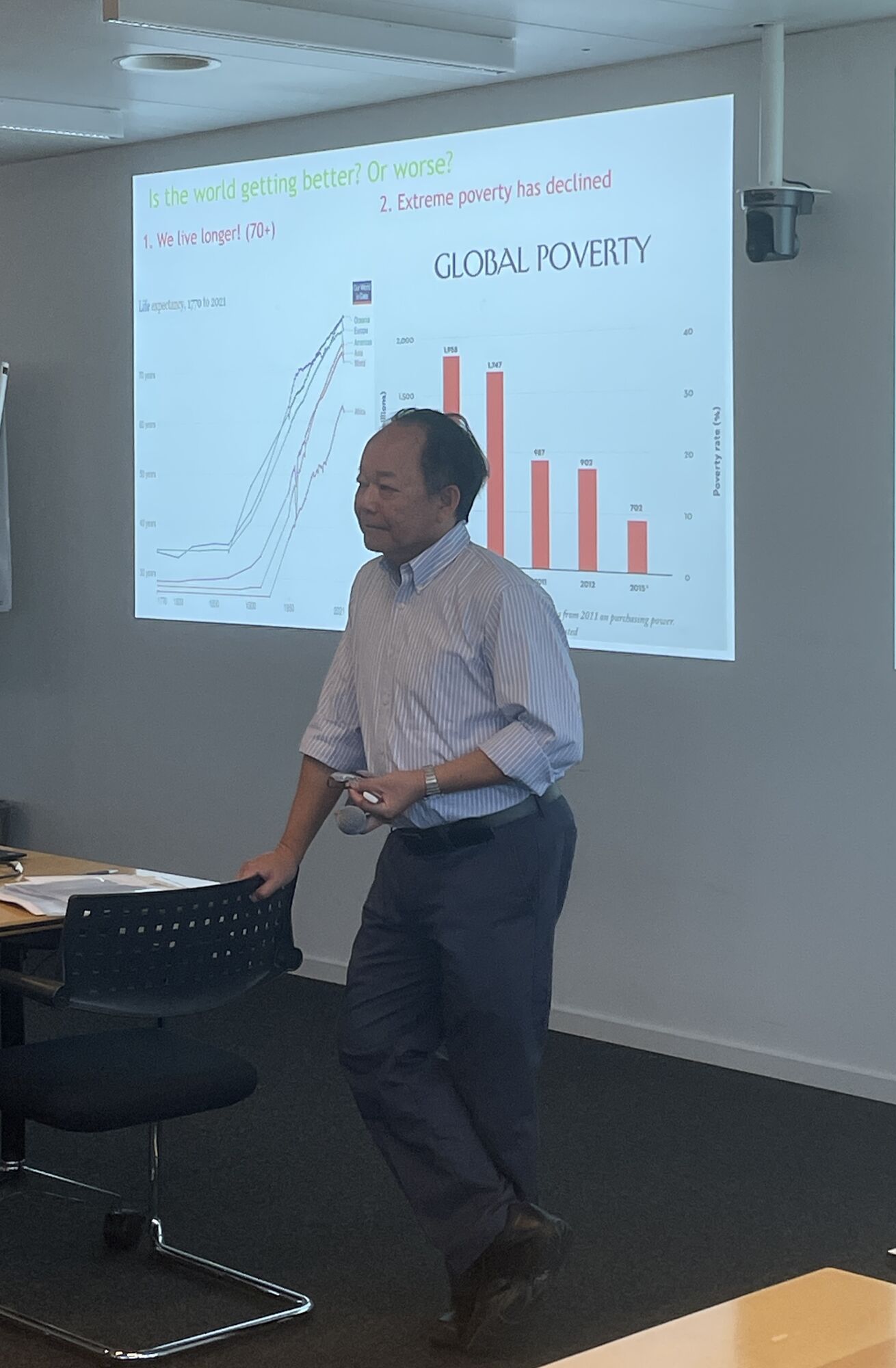 Chris Tang standing in front of his slides presenting