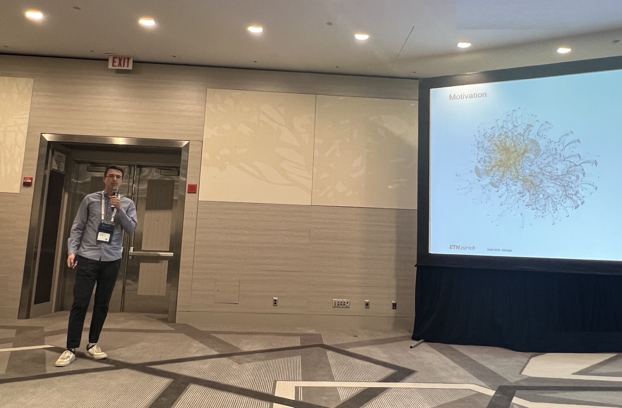 Christian presenting the paper, a network graph can be seen on the right
