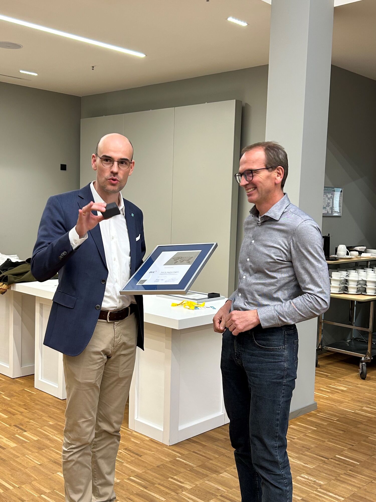 Christoph Meyer holding framed award with Prof. Wagner to his left.